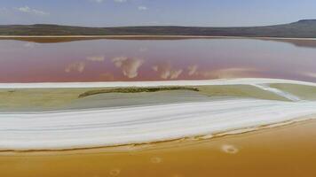 oben Aussicht von Wolken reflektiert im Rosa See. Schuss. hell bunt Orange und Rosa Seen sind getrennt durch Weiß Ufer. schön Betrachtung von Wolken und Blau Himmel im Rosa See foto