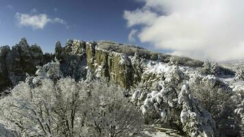 Fantastisch Winter Landschaft von hoch Berg und schneebedeckt Wald auf wolkig, Blau Himmel Hintergrund. Schuss. sonnig Tag im Weiss, Winter Felsen und Bäume bedeckt mit Schnee gegen hell Himmel. foto