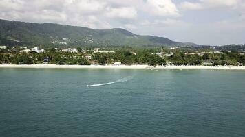 Antenne Aussicht von Weiß Sand Strand und Jet Ski auf das Blau Lagune aqua Meer. Antenne Vogel Auge Aussicht von Jet Ski Kreuzfahrt im hoch Geschwindigkeit im Türkis klar Wasser Meer foto