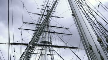 Masten und Kabel von Schiff auf Hintergrund von wolkig Himmel. Aktion. hoch aufragend Masten mit viele verflochten Kabel und Seile von Segeln Schiff auf Hintergrund von wolkig Himmel foto