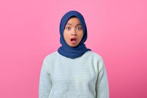 Porträt der überraschten jungen asiatischen Frau, die Kamera auf rosa Hintergrund schaut