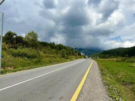 Asphalt Autobahn Straße im das Karpaten Berge mit schwer Wolken über. foto