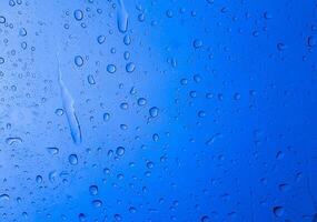 Regentropfen auf der blauen Glasfarbe für Textur und Hintergrund foto