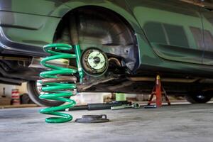 schraubenfeder und stoßdämpfer in der servicewerkstatt wechseln und altes teilautowartungskonzept entfernen foto