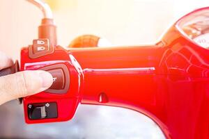 schließen oben Hand ein Mann Drücken Sie das Motorrad Horn Schalter zum Signal Sicherheit auf das Straße Sicherheit Konzept foto