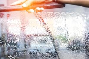 Blase auf das Glas das Windschutzscheibe Scheibenwischer und Auto waschen Mitarbeiter Hand Reinigung Glas von Auto waschen und Reinigung im Gas Bahnhof foto