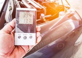 Digital alt Temperatur Meter prüfen Temp. von Reparatur Luft Konditionierung System mit Auto im das Garage Wartung Konzept foto