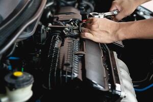 Closeup Schraubenschlüssel in der Hand männlicher Mechaniker repariert Auto in der Garage. Autowartung und Autoservice-Werkstattkonzept foto