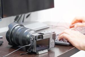 Geschäft Konzept Foto von Kamera und Fotograf ist Arbeiten von seine Kamera mit Computer im Zuhause