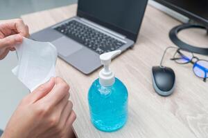 Frauen verwenden Gesicht Maske zum Schutz Virus Weiß Alkohol Gel Brille Computer auf das Holz Tabelle Arbeit von Zuhause Konzept foto