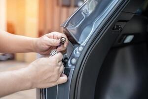 schließen oben Hand ein Mann halt Stecker von Auto Schwanz Beleuchtung prüfen zum Regelmäßigkeiten und Richtigkeit Vor Montage Auto elektrisch Instandhaltung Arbeit Konzept foto