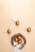 leeren Raum zum Text, ein Banner von glücklich Ostern. gemalt golden Eier, Weiß Gefieder. Kopieren Raum eben legen oben Aussicht Eier mit Flügel fliegen Weg von das Nest foto