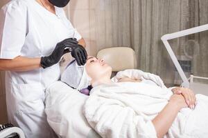 das Kosmetikerin führt aus das Verfahren von Mesotherapie foto