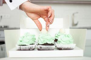 Konditor dekoriert Cupcakes, hausgemacht Kochen, Süßigkeiten. foto