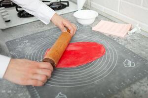Gebäck Koch macht Mastix zu schmücken Kuchen. elastisch Teig, köstlich Gebäck, Kochen Verfahren. Zuhause Produktion, Hobbys, Unternehmerschaft. Rollen aus mit rollen Stift foto