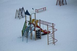 Kinder- Spielplatz auf schneebedeckt Boden foto
