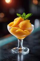 ai generiert Mango Sorbet im ein Glas auf das Tabelle . Eis am Stiel im ein Glas foto