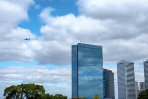 Wolkenkratzer Betrachtung Wolke im Innenstadt und Flugzeug fliegend auf Blau Himmel foto