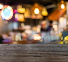 hölzern Tabelle oben auf verschwommen Szene Zähler Bar im Kaffee Geschäft foto