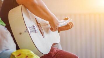 ein jung Mann ist üben spielen Gitarre im ein Musik- trainieren Zimmer Vor durchführen im bestellen zu reduzieren das Fehler von spielen Gitarre auf Bühne. schließen oben jung Mann ist halten Gitarre Akkorde zum ausüben. foto