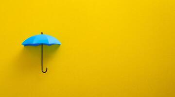 Blau Spielzeug Regenschirm auf Gelb Hintergrund. foto