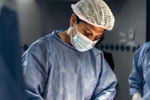 ein erfahren männlich der Chirurg durchführen ein sorgfältig Skoliose Chirurgie im ein medizinisch Einrichtung foto