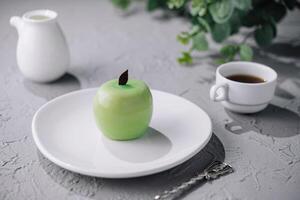 Grün Apfel geformt Mousse Kuchen und Tasse von Kaffee foto