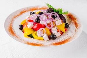 frisch hausgemacht griechisch Salat mit Basilikum Blätter auf ein Teller foto