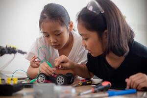 erfinderisch Kinder lernen beim Zuhause durch Codierung Roboter Autos und elektronisch Tafel Kabel im Stengel. konstruieren Roboter Autos beim Zuhause foto