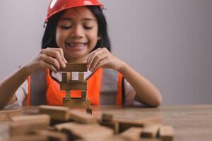 asiatische mädchenkinder, die als ingenieurhelm spielen, lächeln und sind am wochenende glücklich. foto