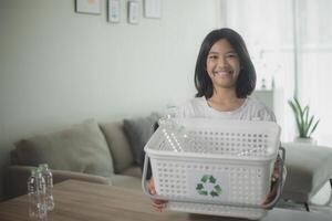 asiatisch wenig Mädchen Trennung recyceln Plastik Flaschen zu Müll Behälter. foto