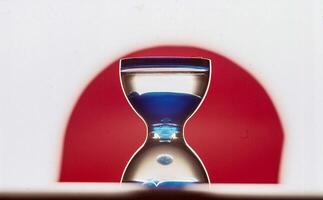 ein Blau Sanduhr mit ein rot Hintergrund foto