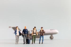 Miniatur Menschen, Reisende begibt sich auf ein herrlich Urlaub, fröhlich Einsteigen ein winzig Flugzeug foto