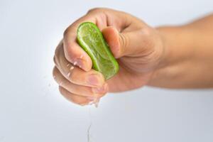 weiblich Hand quetschen Hälfte frisch Zitrone isoliert auf Weiß Hintergrund. quetschen frisch Zitrone schließen hoch. Höhe Vitamin c natürlich foto