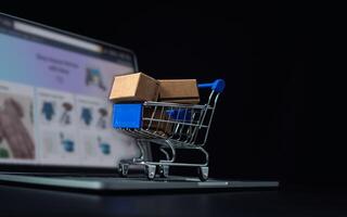 Kisten im ein Einkaufen Auto auf ein Laptop Klaviatur. Ideen Über online Einkaufen, online Einkaufen ist ein bilden von elektronisch Handel Das erlaubt Verbraucher zu direkt Kaufen Waren von Verkäufer Über das Internet. foto