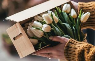 ai generiert jemandes Hand ist halten ein Box von Weiß Tulpen foto