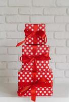 Haufen roter Geschenkboxen auf weißem Wandhintergrund foto