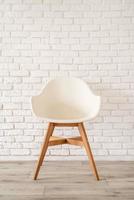 weißer Stuhl auf einem Backsteinmauerhintergrund foto