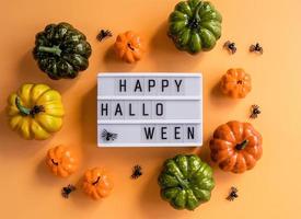 Happy Halloween Cinema Lightbox mit Spinnen und Kürbisse Draufsicht auf orangem Hintergrund foto