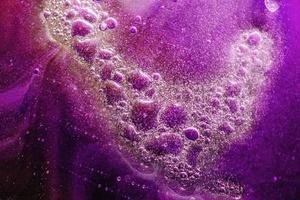 abstrakter Hintergrund oder Textur mit Ölblasen auf lila Wasseroberfläche foto