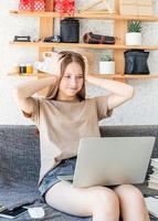 Schockiertes Teenager-Mädchen, das zu Hause mit ihrem Laptop studiert