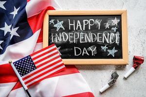 Nahaufnahme der amerikanischen Flagge mit einer Tafel mit Text Happy Independence Day Draufsicht foto