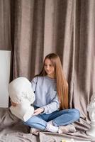 junge Künstlerin sitzt in ihrem Atelier mit dem Kopf aus Leinwand und Gips Sokrates