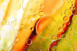 leuchtend gelbe und grüne bunte Blasen auf der Wasseroberfläche im abstrakten Hintergrund foto