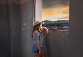 jung Frau Tourist suchen beim das Sonnenuntergang durch ein alt Fenster im Granada, Nicaragua foto