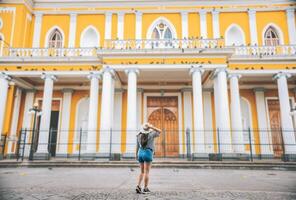 Rückseite Aussicht von Tourist Mädchen suchen beim Dom. Tourist Frau von zurück suchen beim ein Kathedrale im ein Quadrat. Granada, Nicaragua foto