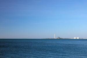 ein industriell Fabrik im das Vordergrund ist das Meer. foto