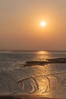 goldene Strände und Fischerboote am Strand in der Abenddämmerung foto