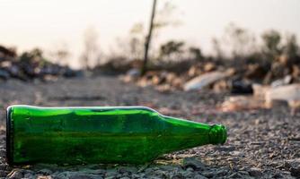 grüne Glasflasche auf dem Boden bei unscharfem Hintergrund, foto