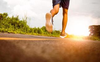 Teenager-Läufer laufen auf der Straße für Bewegung. Nahaufnahme von Beinen. gesundes Lebensstilkonzept. foto
